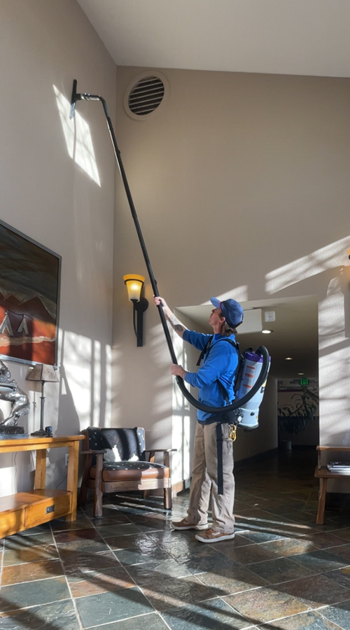 Photo: dusting high objects by PEAK Window Cleaning.